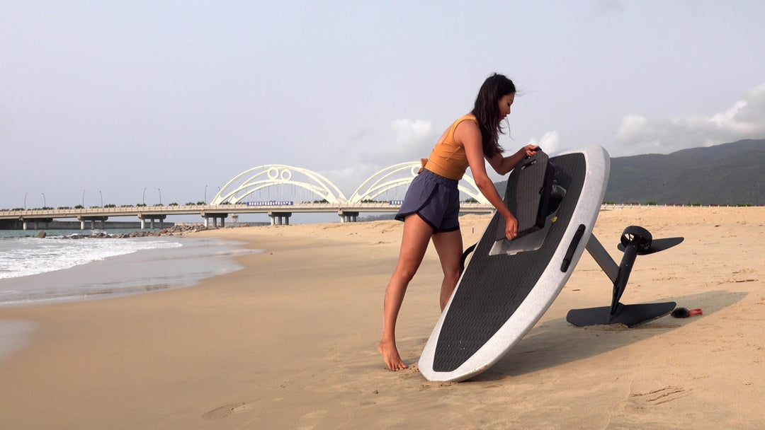 a girl is putting the battery into Waydoo efoil board